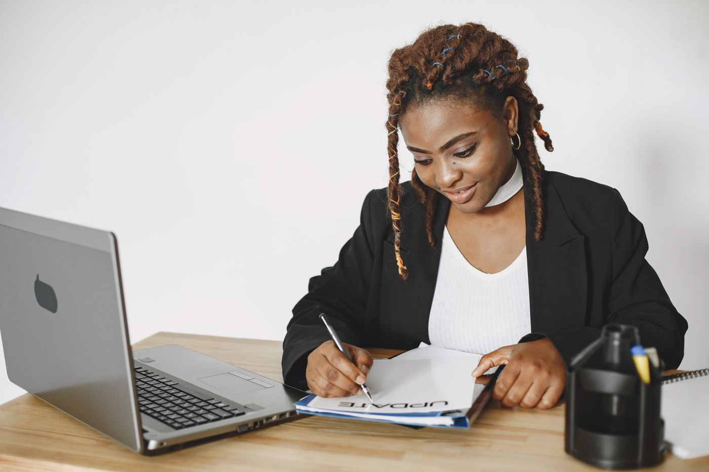 Small business owner reviewing documents beside a laptop